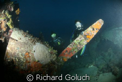 Two divers behind engine of the Flying Emily Boat-Truk La... by Richard Goluch 